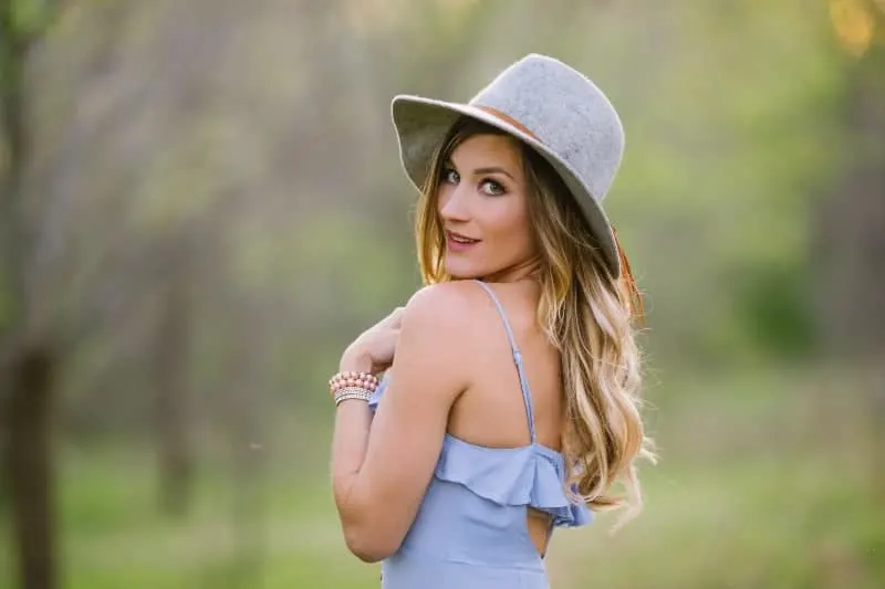 attractive woman wearing blue dress and gray hat
