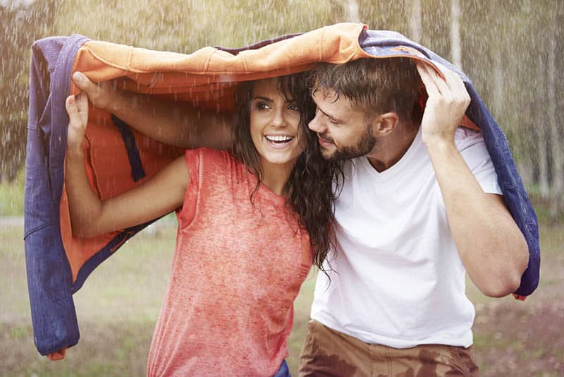 couple under jacket during rain