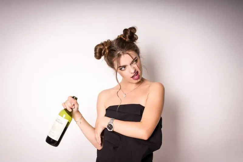 drunk woman holding a bottle of wine