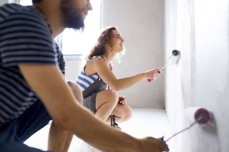 uomo e donna che dipingono il muro