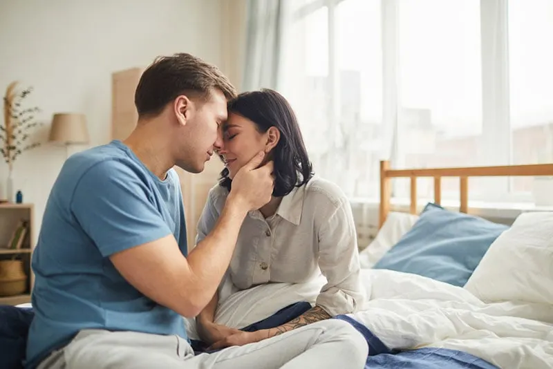 man comforting woman on the bed
