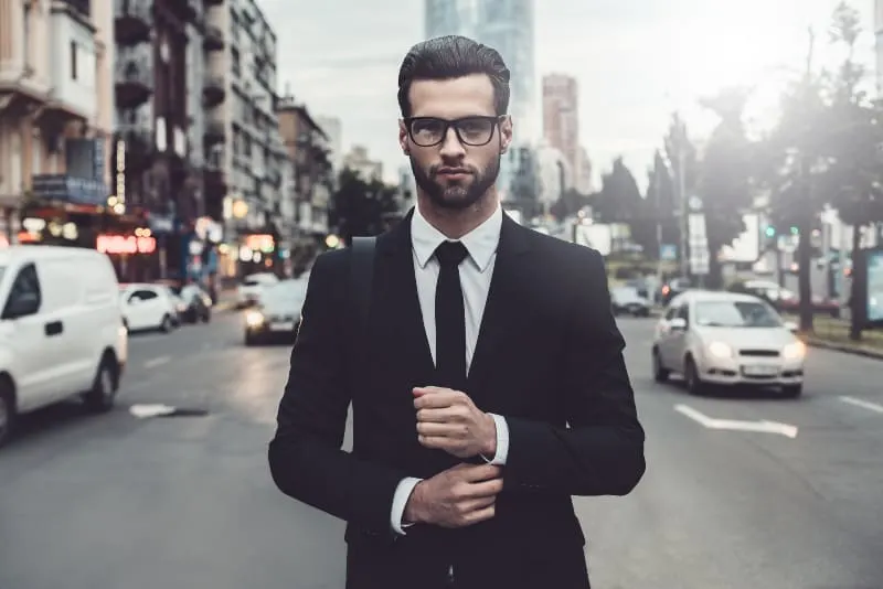 man wearing suit standing on the road