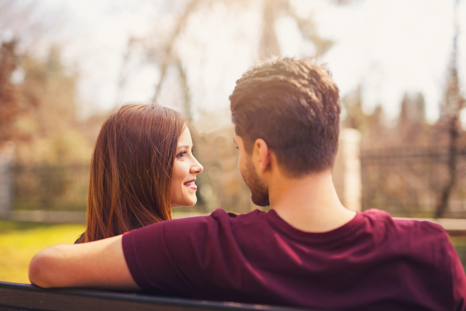 num banco de jardim, um casal senta-se e conversa