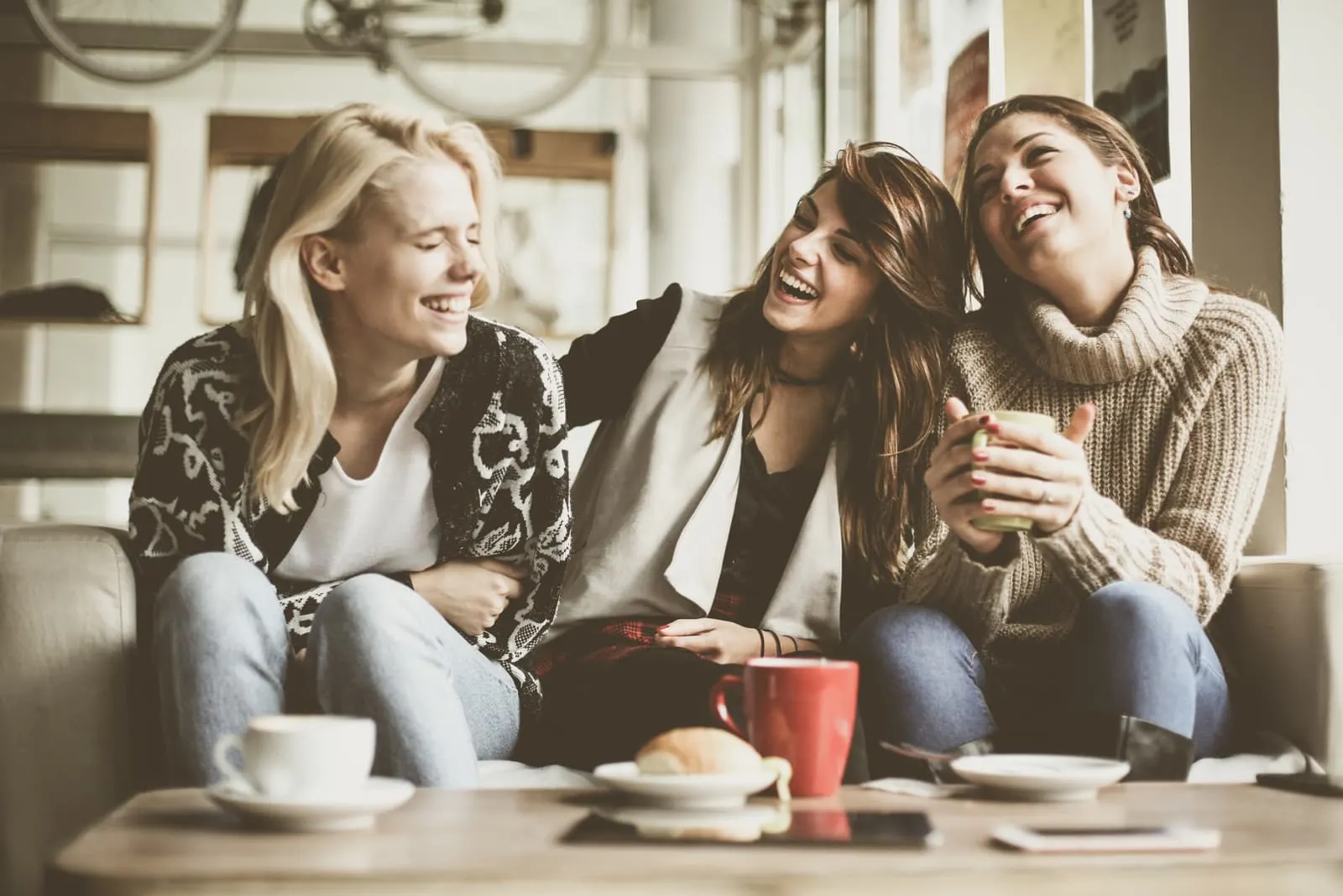 three friends smiling at cafe