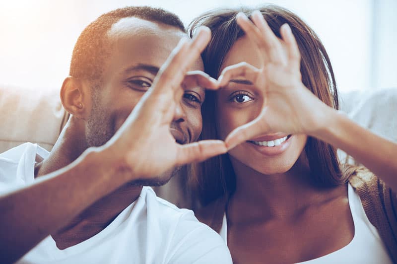 young couple making heart with fingers