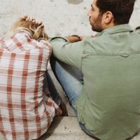 man sitting beside upset woman