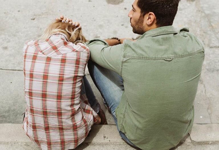 man sitting beside upset woman