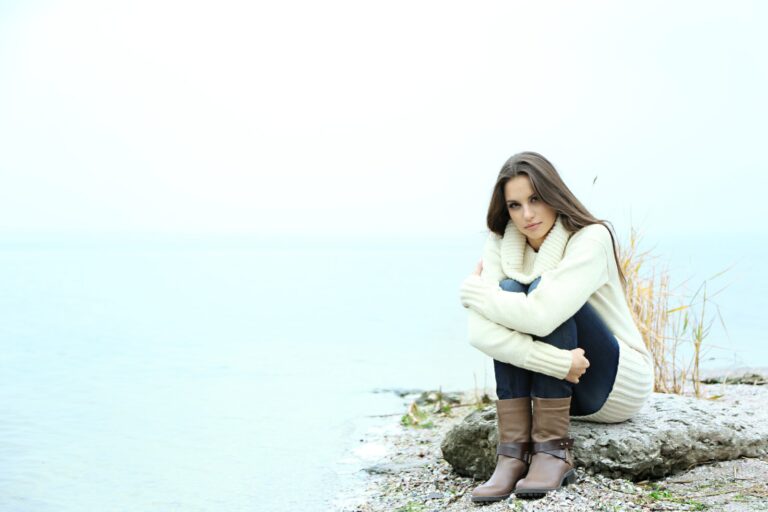 a woman sitting by the lake