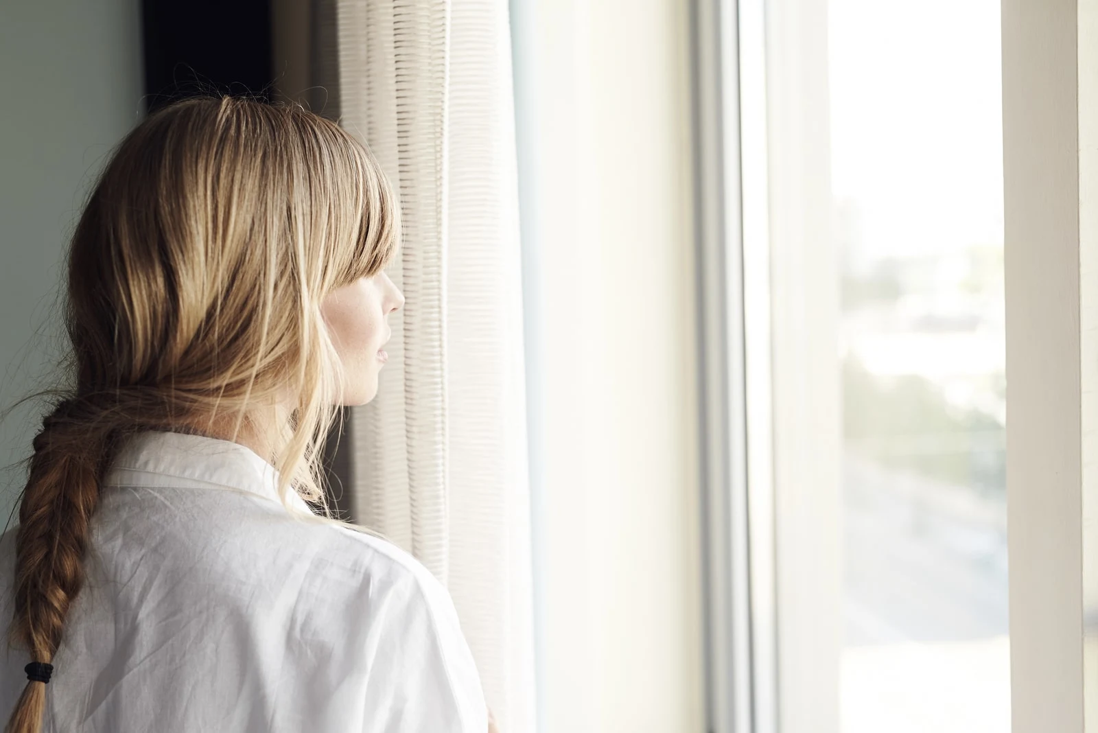  blond woman looking through window