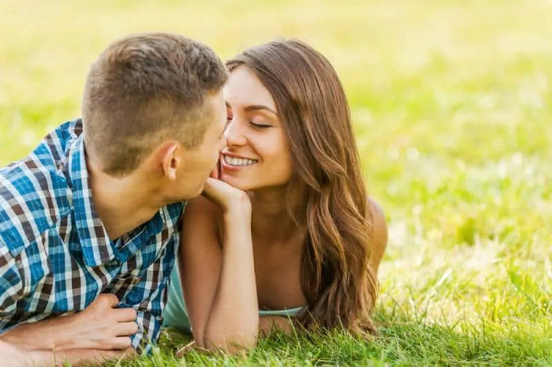 couple lying on the grass while looking at each other