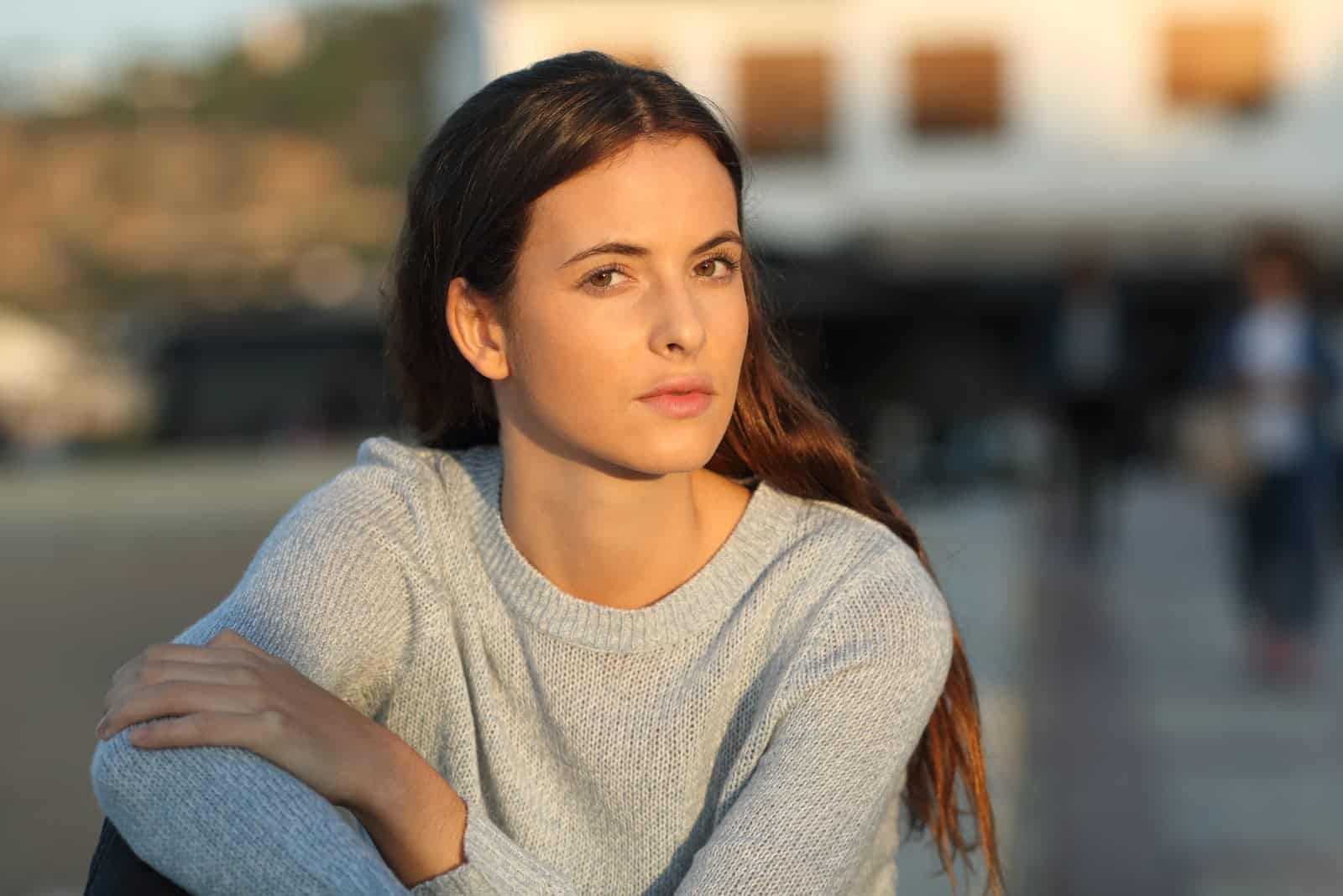 giovane donna seria seduta all'aperto