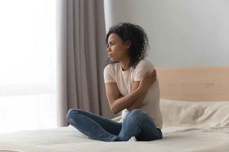 worried woman sitting on the bed
