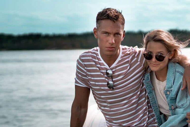 un hombre y una mujer junto al mar se abrazan