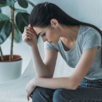 thoughtful woman sitting at home