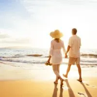 romantic loving couple at sunset walking on the beach