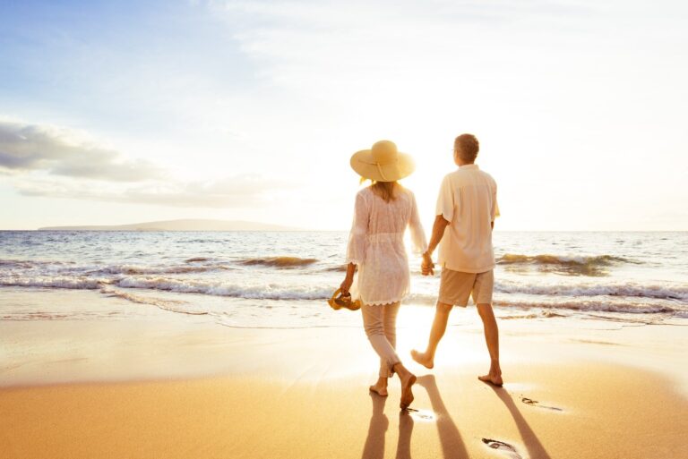 coppia romantica e innamorata al tramonto che cammina sulla spiaggia