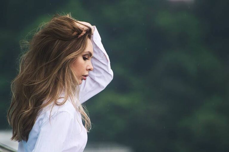 side view of woman touching her hair outside