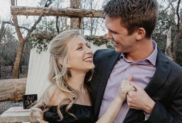 casal encantador a olhar um para o outro e a sorrir lá fora