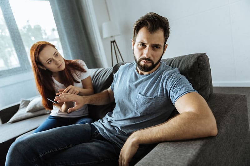 angry man sitting with sad woman