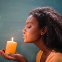 woman blowing to candle
