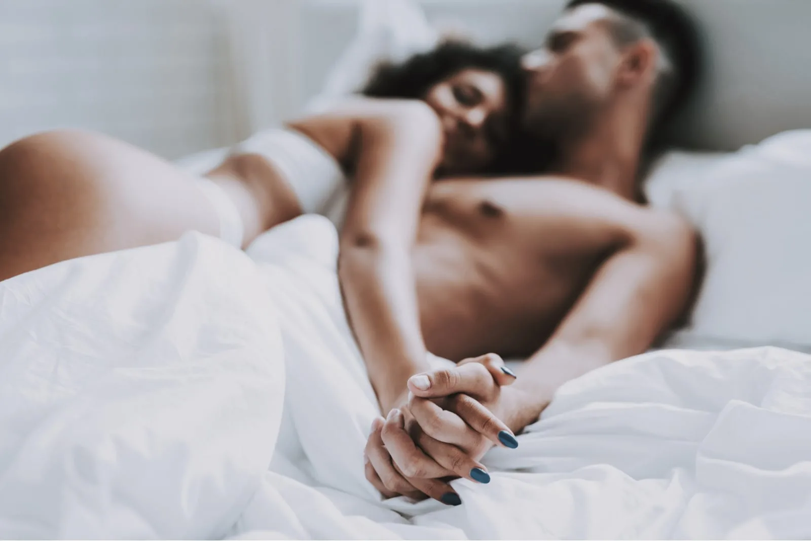 a man and a woman embrace in bed