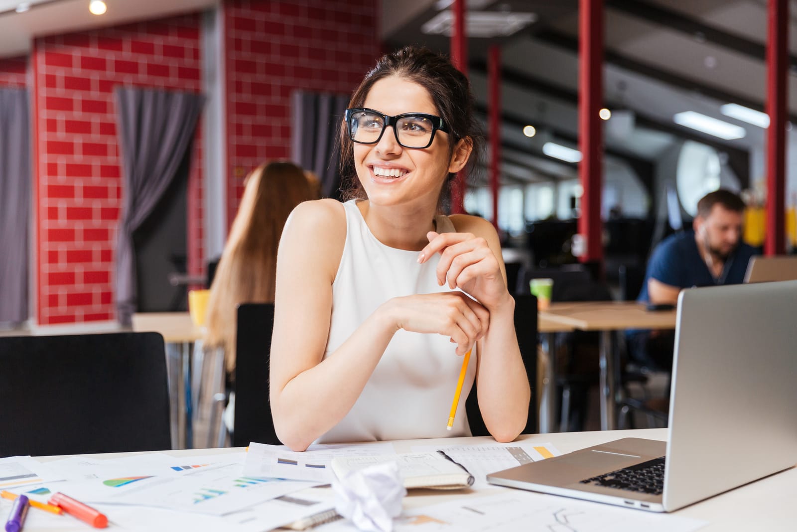una mujer de negocios sonriente trabajando con un portátil en una cafetería