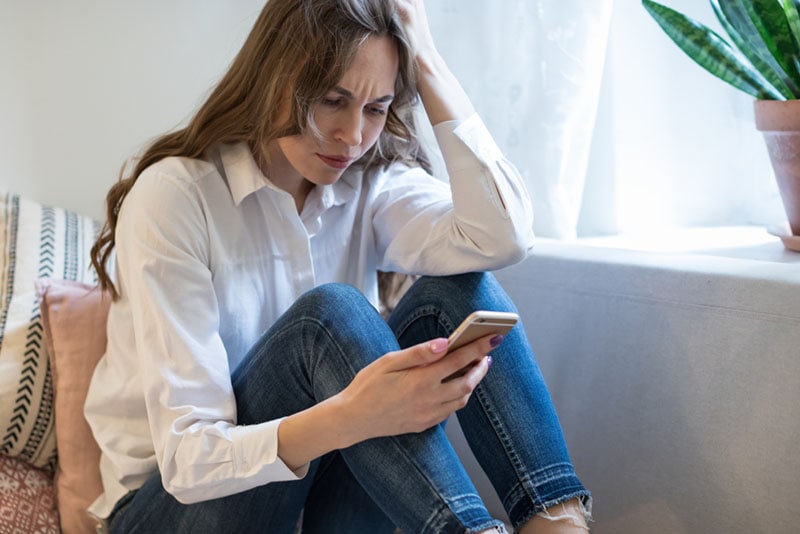 mujer enfadada mirando el teléfono 