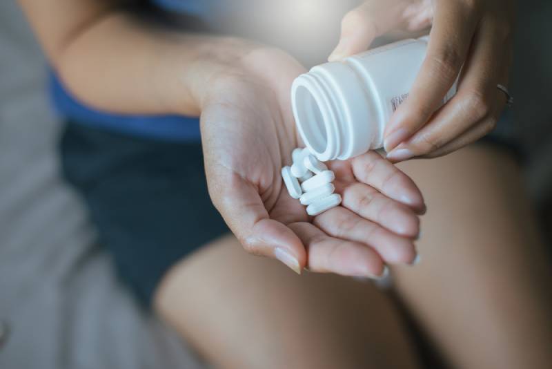 close up photo of female hand holding a pills