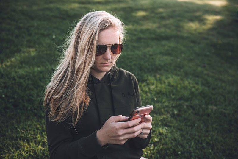 serious blond woman texting