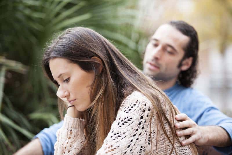 unhappy couple sitting outside