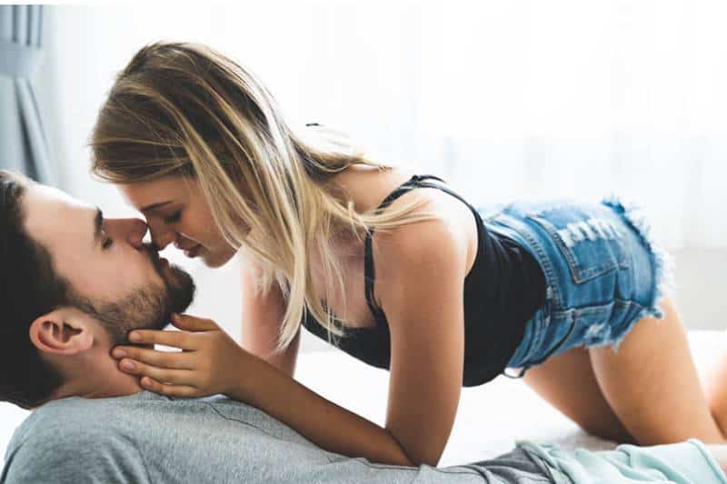 mulher a fazer sexo com homem enquanto ele está deitado na cama