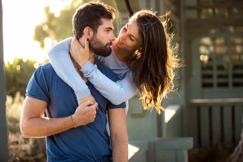 woman hugging man from back and looking at each other