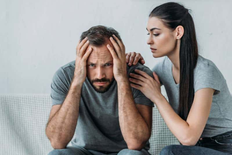 woman trying to calm her boyfriend at home