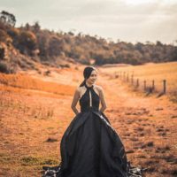 mujer con vestido negro caminando en la naturaleza