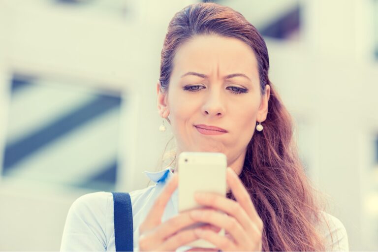 a confused woman is reading something on her cell phone