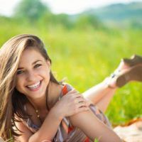 mujer feliz sonriendo y tumbada en la hierba