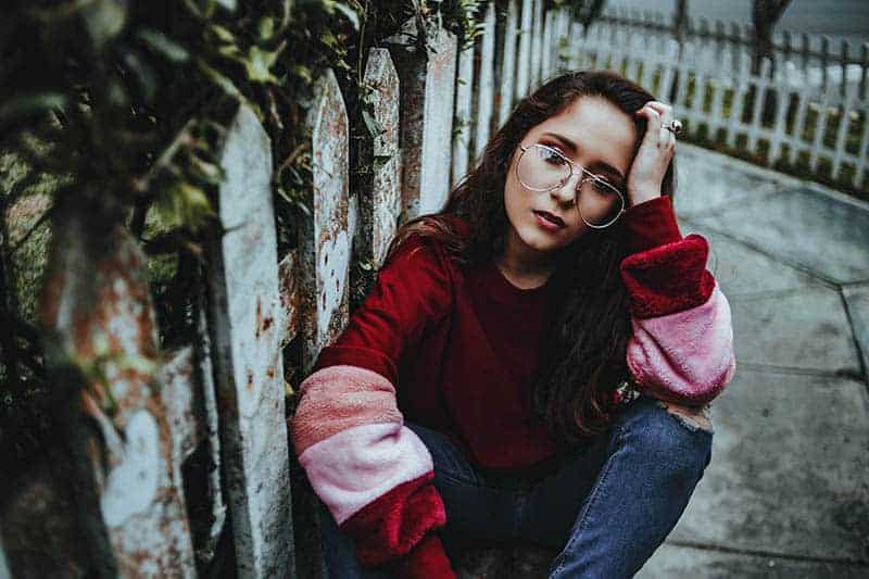 woman sitting on sidewalk
