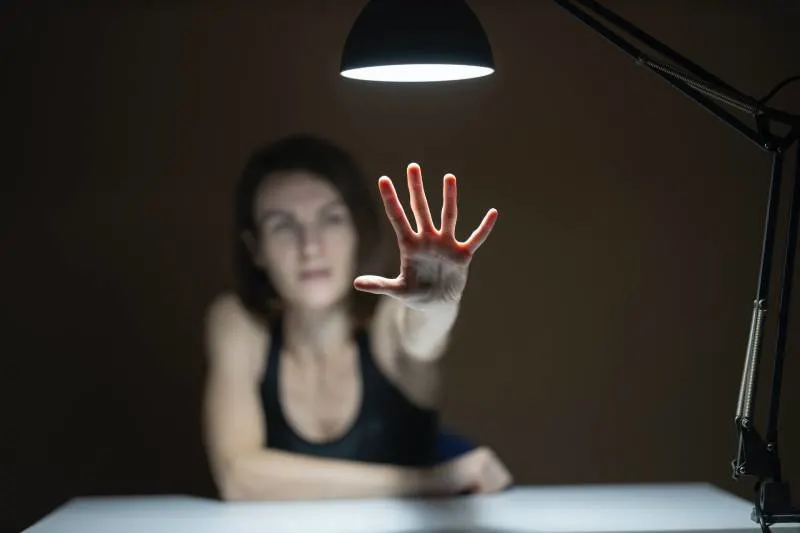 Woman in black tank top raising her hands