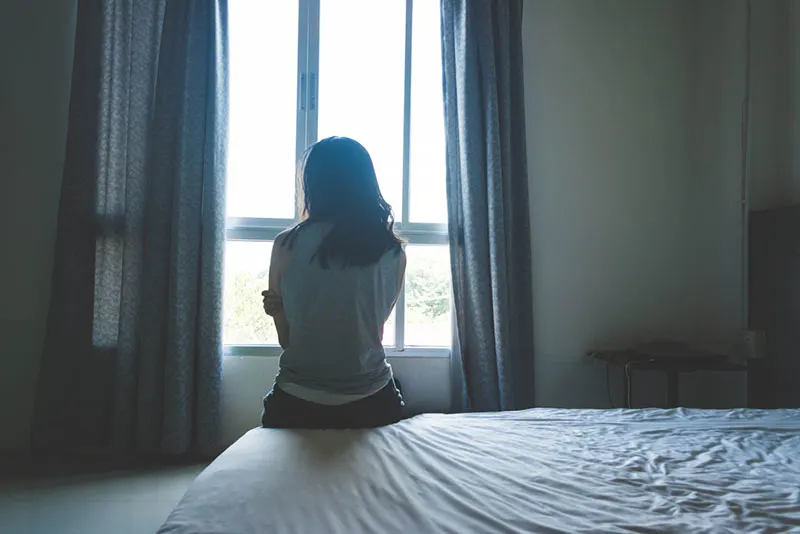 depressed woman sitting on the bed