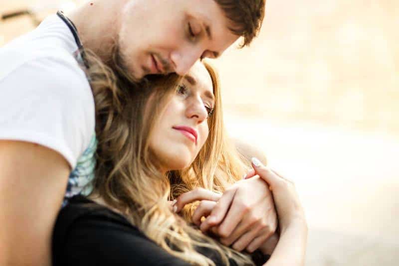 man hugging woman from back