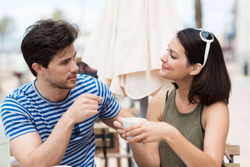 man talking to woman at coffee bar