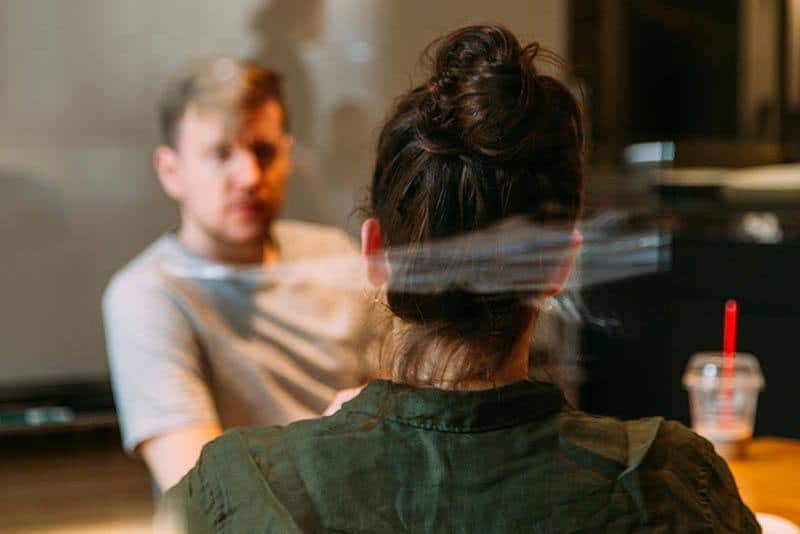 Foto con messa a fuoco ridotta di uomo e donna che parlano in un caffè