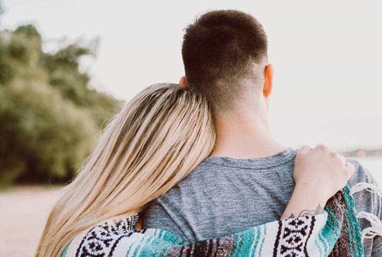 back view of woman hugging man over shoulder