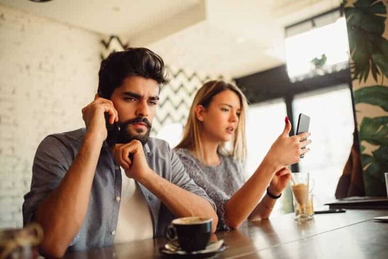 couple in cafe using their smartphones