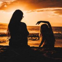 silhueta de mãe e filha na praia