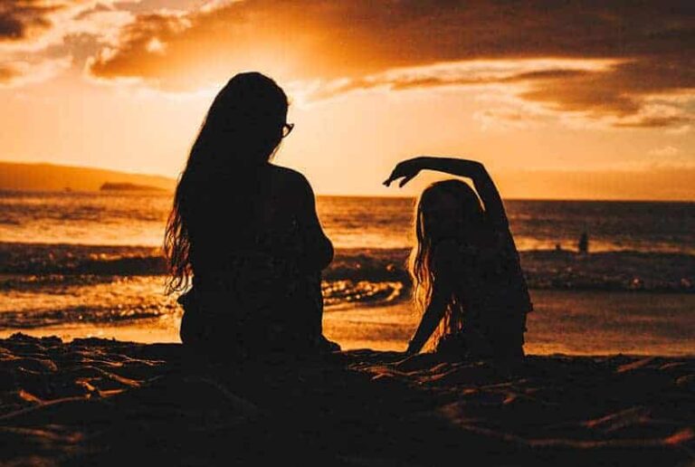 silhouette of mother and daughter on the beach