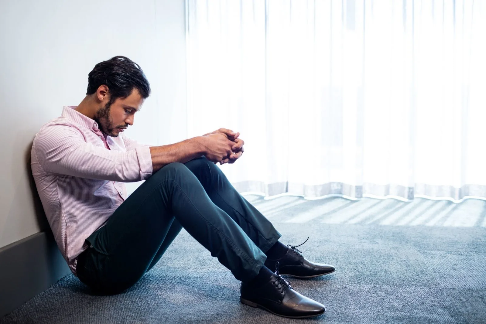 a man sits on the floor pensive