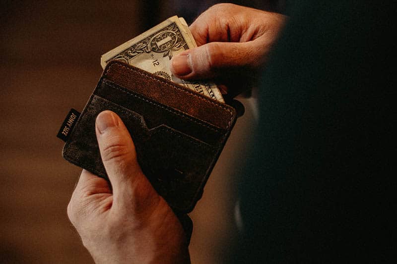 hombre con cartera y dinero en la mano