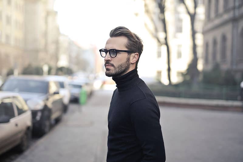 man wearing eyeglasses and black sweatshirt standing outside