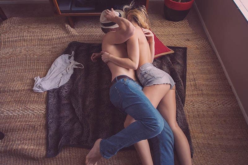 apasionada pareja besándose en el suelo